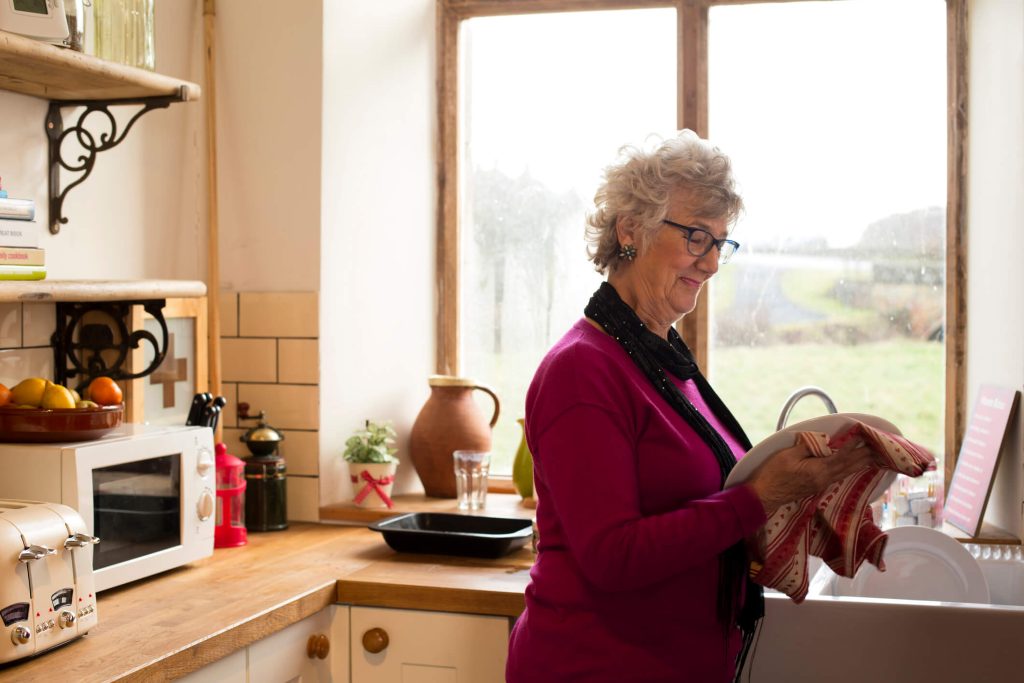 Photo of senior woman washing dishes