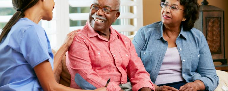Senior couple speaking to caregiver