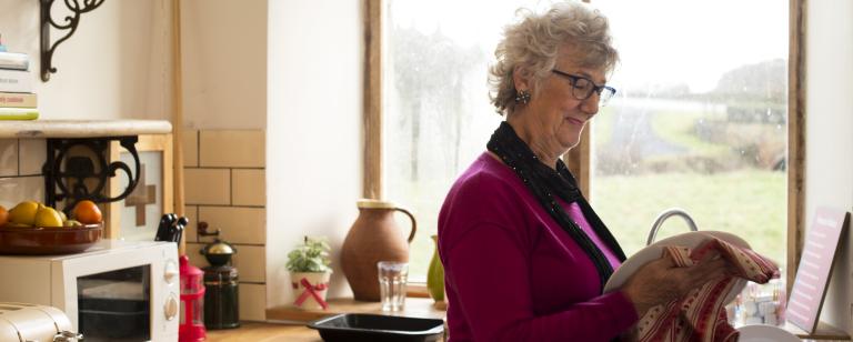Senior woman drying dishes