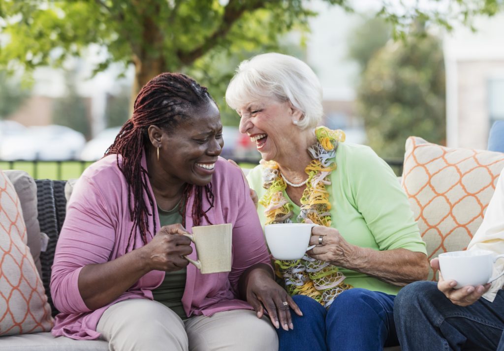 Senior women laughing and drinking tea together