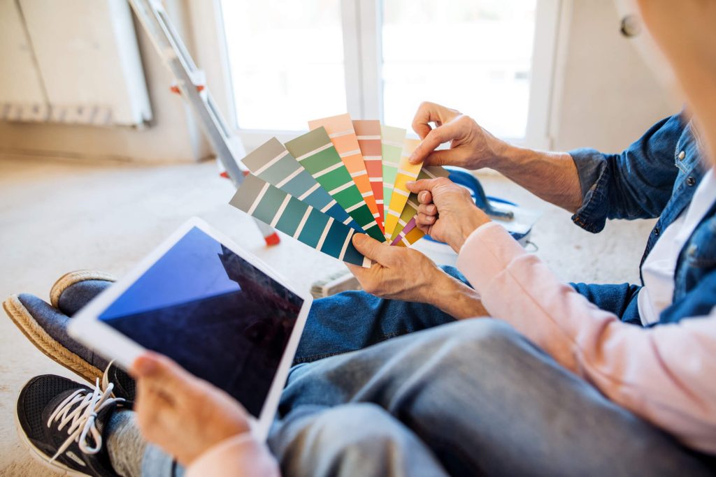 Senior couple looking at paint swatches and ipad together