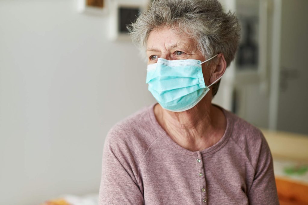 Senior Woman Wearing Masks gazing out window
