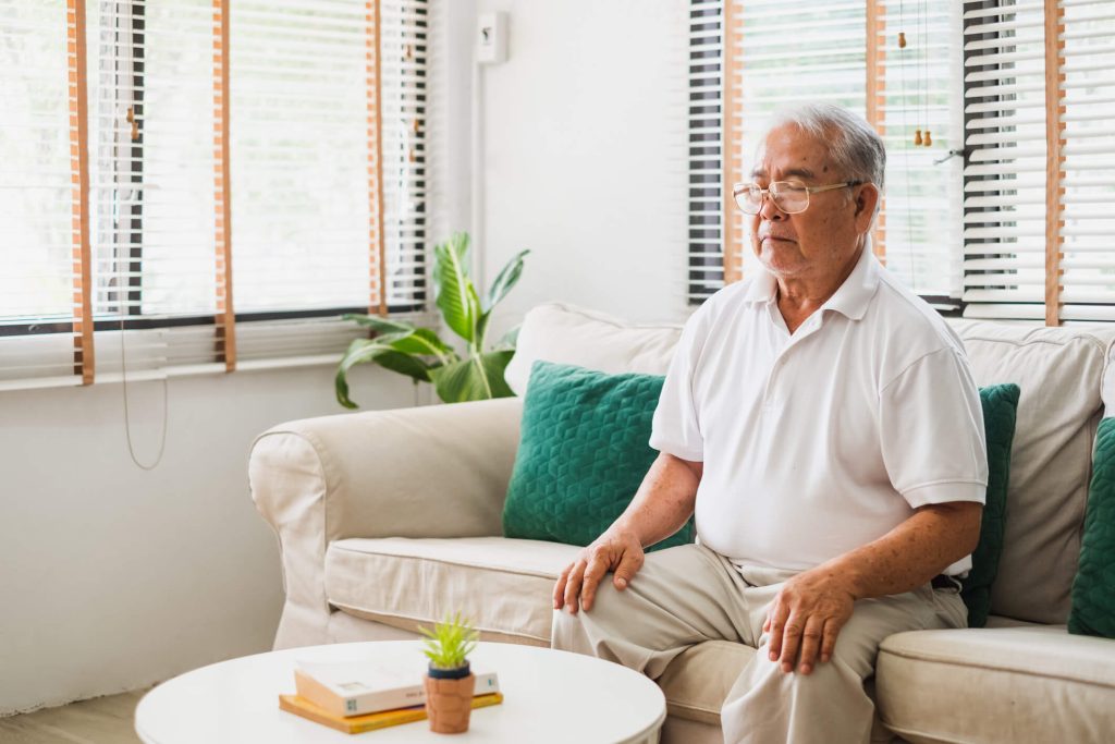 Senior man meditating on couch