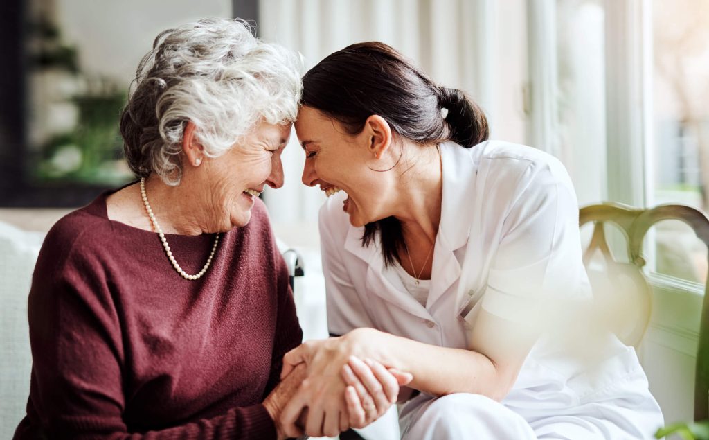 Senior woman laughing with caregiver