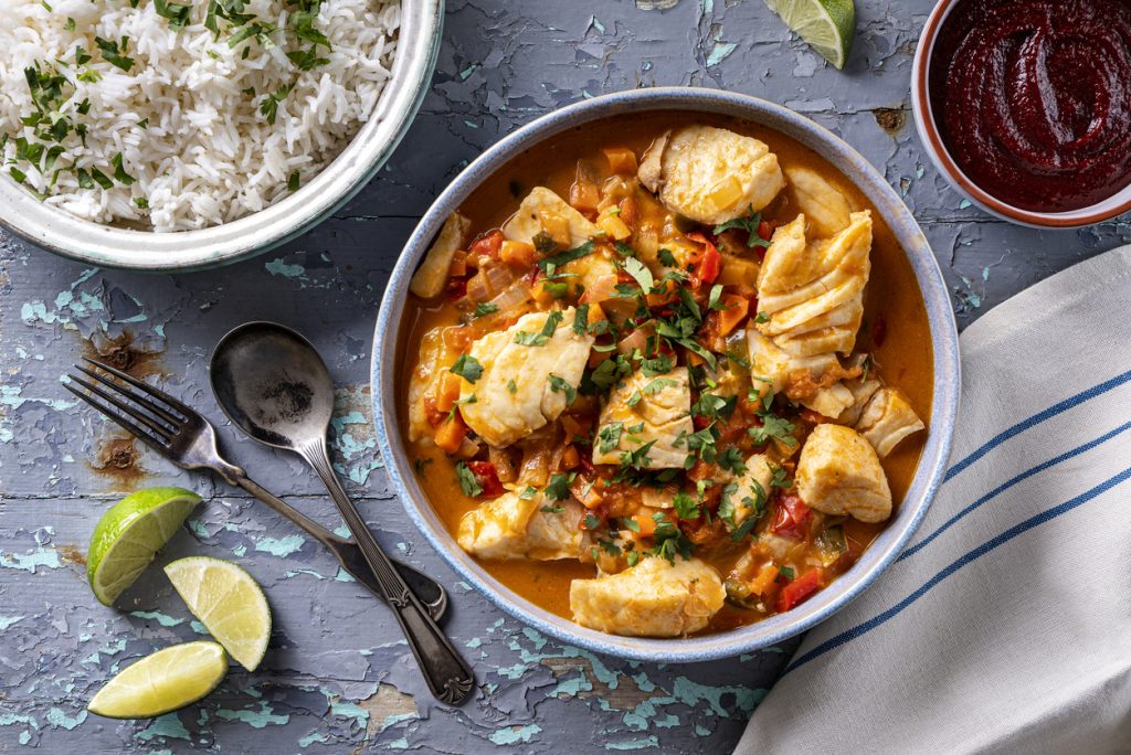 Delicious Brazilian fish stew moqueca with tomato, lime, red pepper, coconut milk and cilantro.