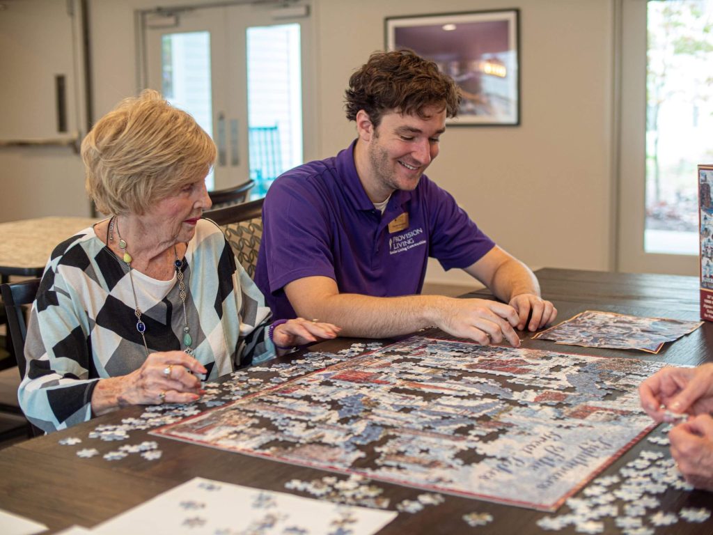Provision Living team member and resident looking at puzzle on a table